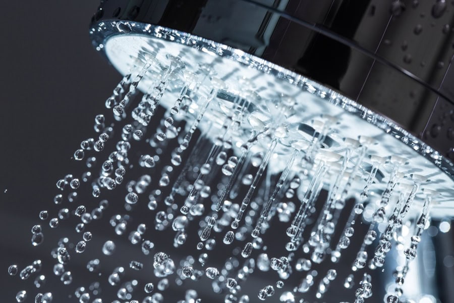 Help! I Have No Hot Water. Shower Head with Water Stream on Black Background.